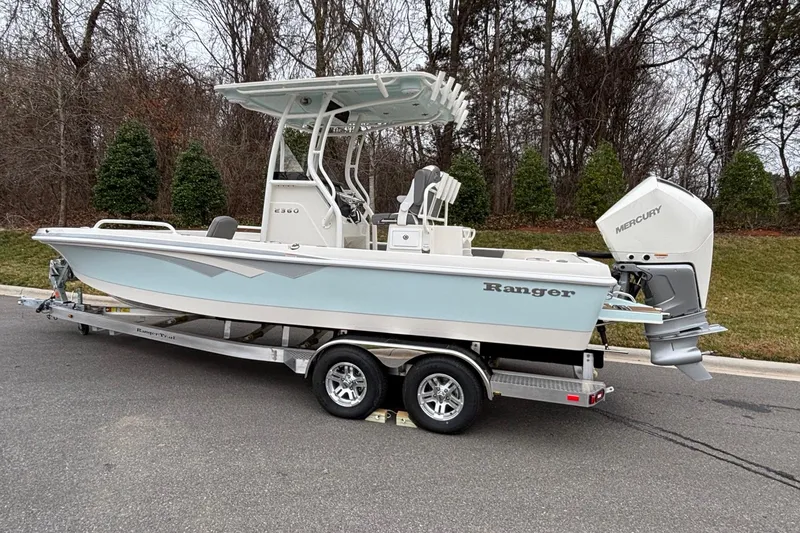Slide: The Image of 2025 Ranger 2360 Bay boat on trailer, parked on road, with Mercury outboard motor. - 3