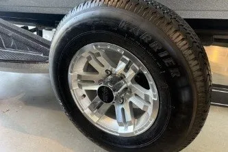 Slide: The Image of 2025 Ranger Z518 Cup-Equipped trailer wheel with Karrier tire in a garage setting. - 11