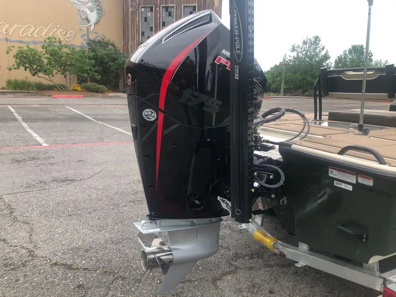 Slide: The Image of 2025 Mako 18 Pro Skiff Backwater Edition with powerful outboard motor in parking lot. - 5