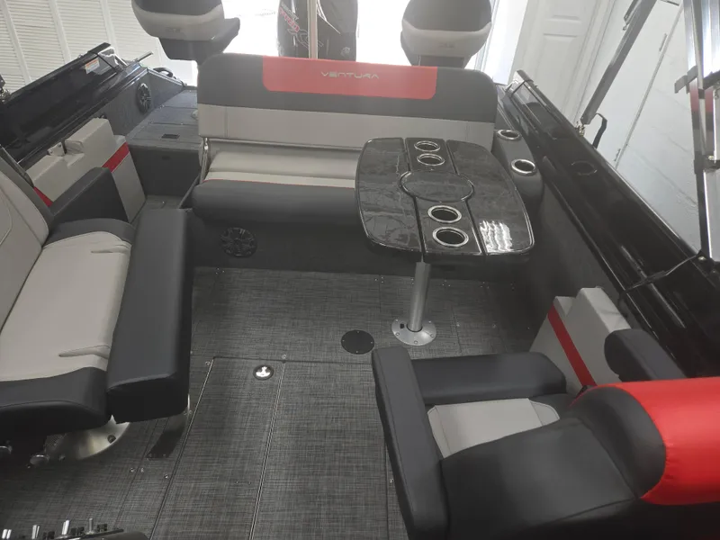 Slide: The Image of 2025 Princecraft Ventura 230 WRL boat interior with seating and table, featuring modern design and cup holders. - 18