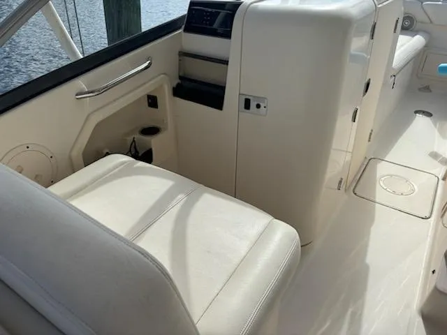 Slide: The Image of 2016 Grady-White Freedom 275 boat interior with white seating and control panel. - 11