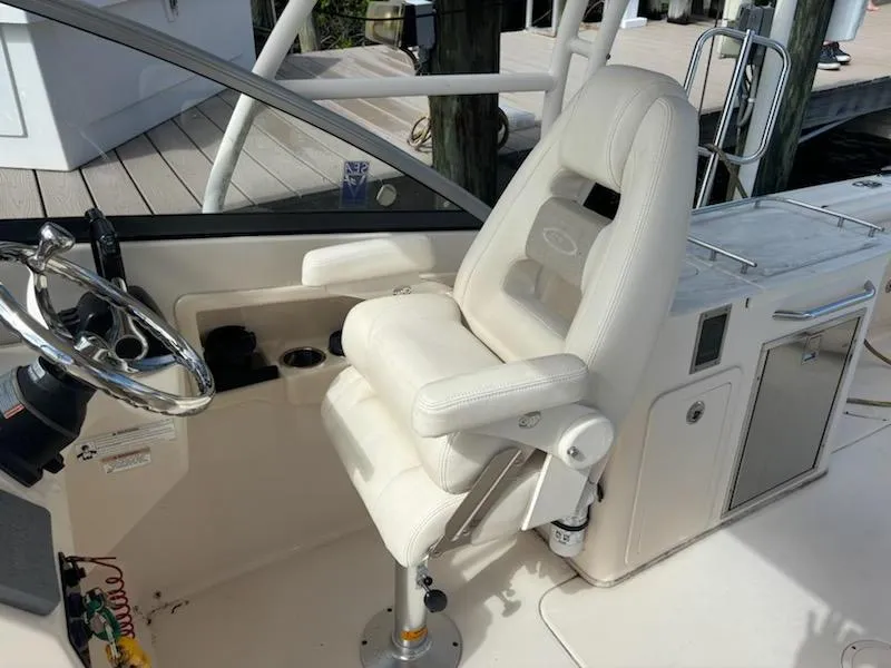 Slide: The Image of 2016 Grady-White Freedom 275 boat helm with white captain's chair and steering wheel. - 12