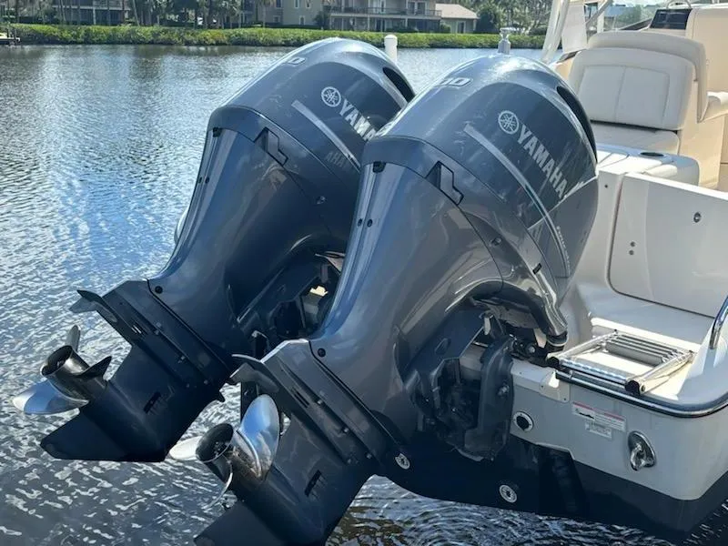 Slide: The Image of Twin Yamaha outboard motors on a 2016 Grady-White Freedom 275 boat, docked by the water. - 5