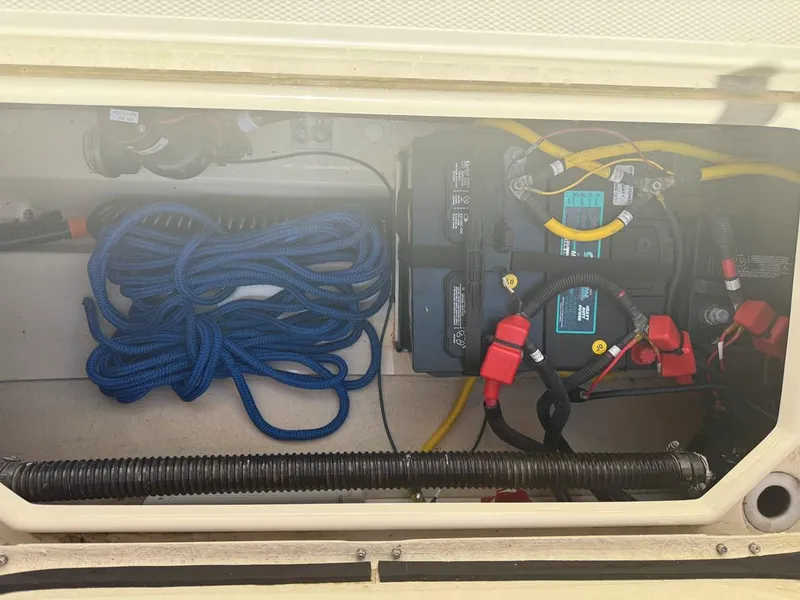 Slide: The Image of 2021 Ranger Tugs R-23 boat compartment with blue rope and battery setup. - 11