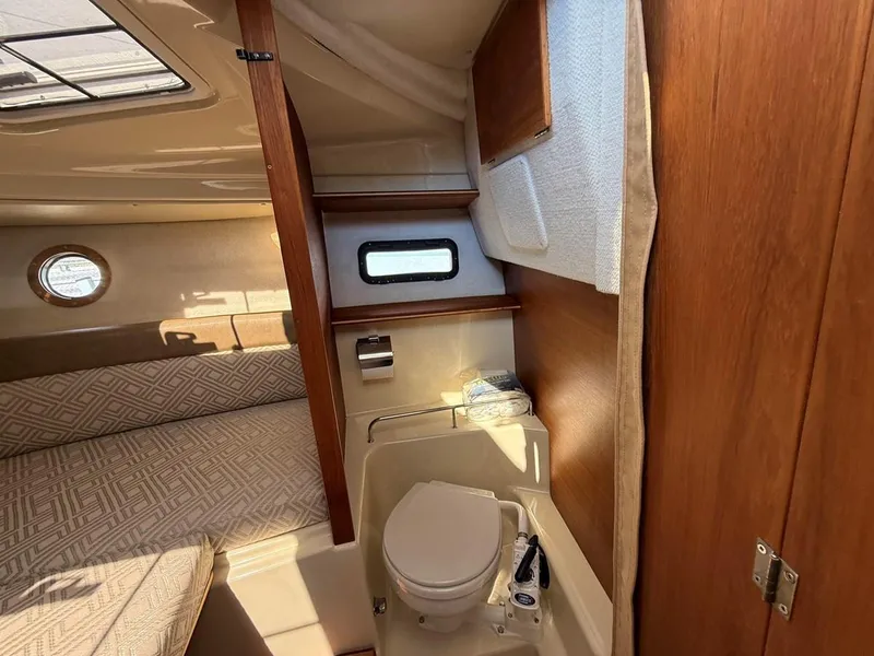 Slide: The Image of 2021 Ranger Tugs R-23 interior cabin with bed and compact bathroom. - 18