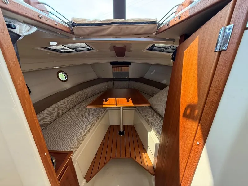 Slide: The Image of 2021 Ranger Tugs R-23 cabin interior with wood accents and seating area. - 19