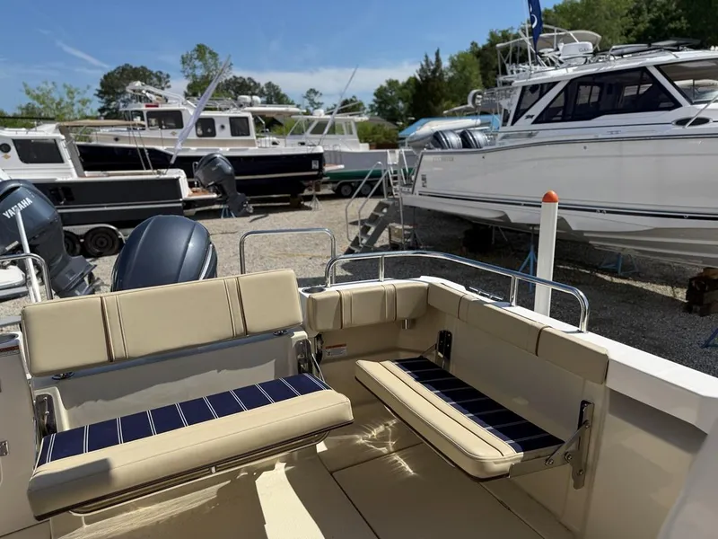 Slide: The Image of 2021 Ranger Tugs R-23 boat interior with seating, docked among other boats. - 5