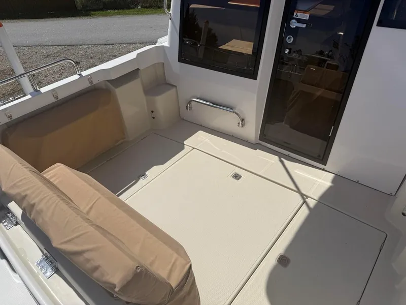 Slide: The Image of 2021 Ranger Tugs R-23 boat interior with beige seating and spacious deck area. - 6