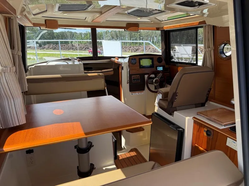 Slide: The Image of Interior of 2021 Ranger Tugs R-23 boat with seating, table, and navigation controls. - 9