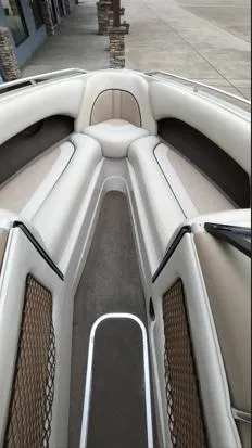 Slide: The Image of 2002 Malibu 23 LSV boat interior with beige seating and storage nets. - 3