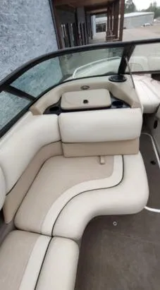 Slide: The Image of 2002 Malibu 23 LSV boat interior with beige seating and cup holders. - 6