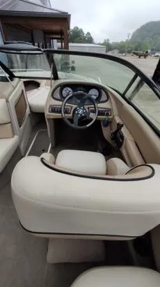 Slide: The Image of Interior of 2002 Malibu 23 LSV boat with beige seating and dashboard controls. - 7
