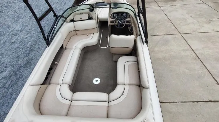 Slide: The Image of 2002 Malibu 23 LSV boat interior with beige seating and steering wheel. - 9