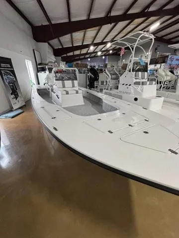 Slide: The Image of 2025 Majek 25 Xtreme boat displayed in a showroom with sleek design and spacious deck. - 3