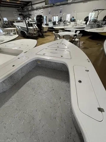 Slide: The Image of 2025 Majek 25 Xtreme boat interior in showroom, featuring spacious deck and storage compartments. - 5