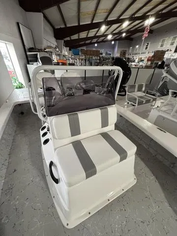 Slide: The Image of 2025 Majek 25 Xtreme boat interior with seating and console in showroom. - 6