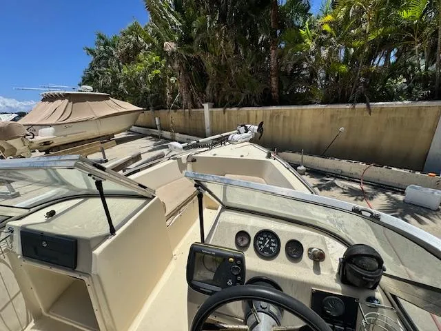 Slide: The Image of 1993 Key West 1720 DC boat interior with steering wheel and gauges, parked outdoors. - 13