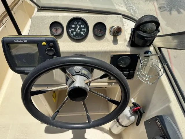Slide: The Image of 1993 Key West 1720 DC boat dashboard with steering wheel, gauges, and navigation equipment. - 14