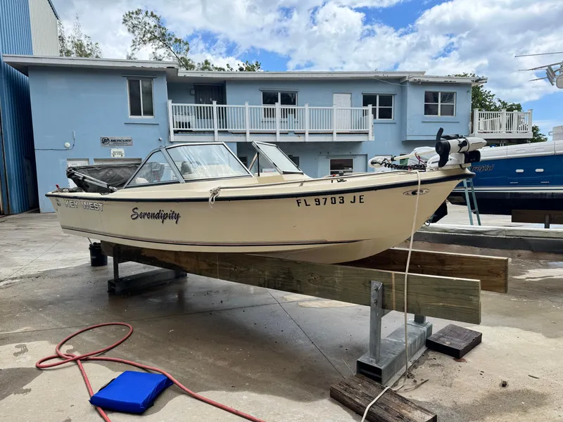 Slide: The Image of 1993 Key West 1720 DC boat on a stand, with a blue building in the background. - 4