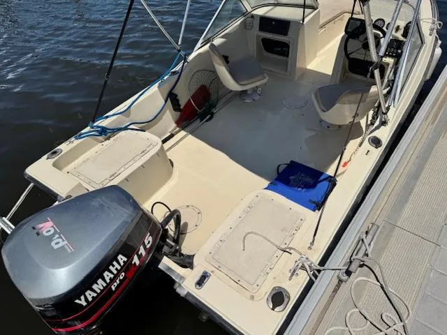 Slide: The Image of 1993 Key West 1720 DC boat with Yamaha 115 outboard motor docked by the water. - 7