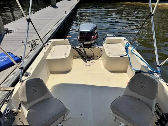 Slide: The Image of 1993 Key West 1720 DC boat interior with seating and outboard motor at dock. - 9