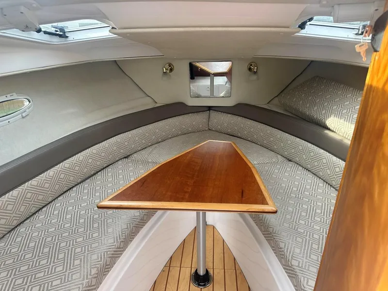 Slide: The Image of 2017 Cutwater C-24 cabin interior with wooden table and cushioned seating. - 10