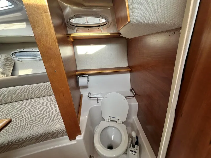 Slide: The Image of 2017 Cutwater C-24 boat interior with compact bathroom and wooden accents. - 11