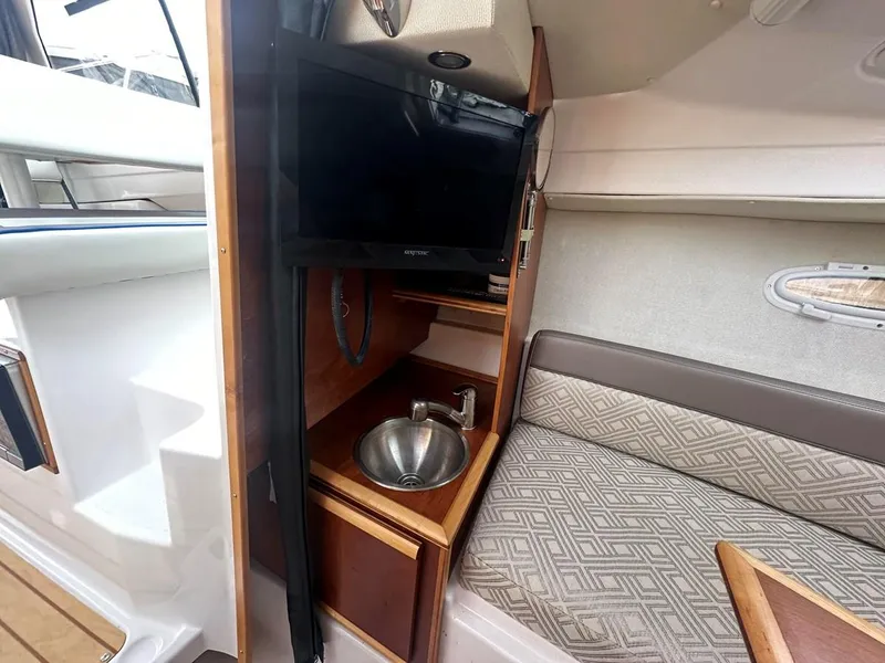Slide: The Image of 2017 Cutwater C-24 interior with TV, sink, and cushioned seating area. - 12