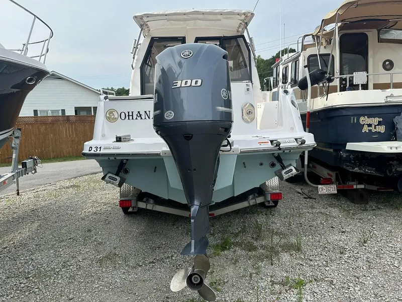 Slide: The Image of 2017 Cutwater C-24 boat with a 300 horsepower outboard motor, parked on gravel. - 2