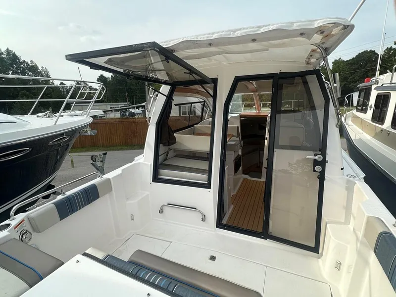 Slide: The Image of 2017 Cutwater C-24 boat interior with open cabin door, showcasing seating and helm area. - 3