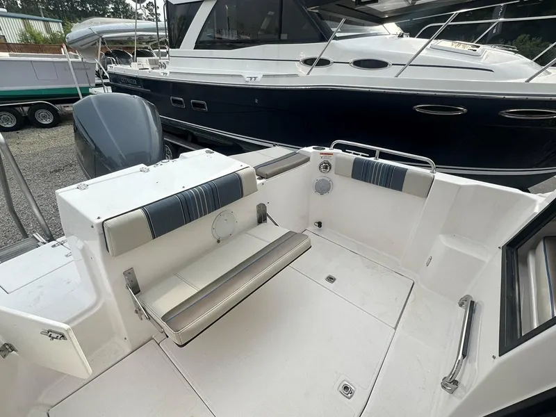 Slide: The Image of 2017 Cutwater C-24 boat interior with seating and motor, docked beside another vessel. - 4