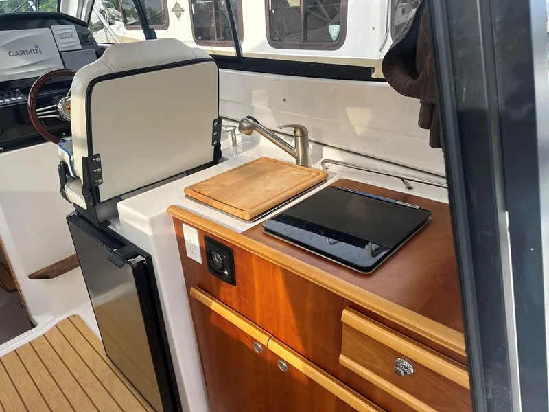 Slide: The Image of 2017 Cutwater C-24 boat interior with kitchenette, featuring sink, cutting board, and tablet. - 6