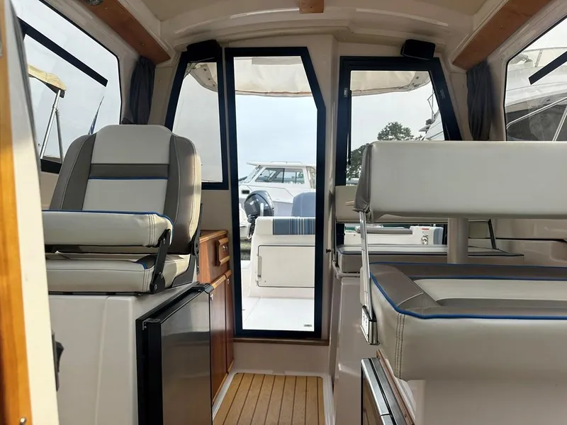 Slide: The Image of Interior of a 2017 Cutwater C-24 boat, featuring seating and a compact kitchenette. - 9