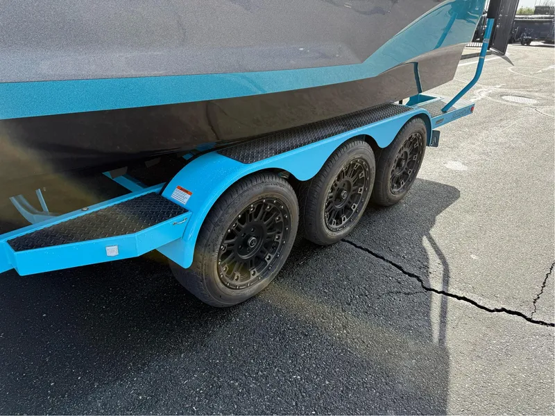 Slide: The Image of 2019 MasterCraft X24 boat trailer with triple axles on asphalt. - 12