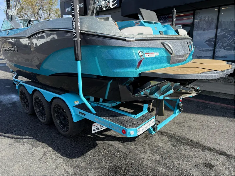 Slide: The Image of 2019 MasterCraft X24 boat on a trailer, featuring a sleek blue and gray design. - 13