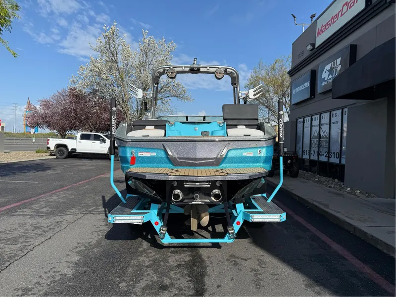 Slide: The Image of 2019 MasterCraft X24 boat, blue, parked outside dealership on sunny day. - 3
