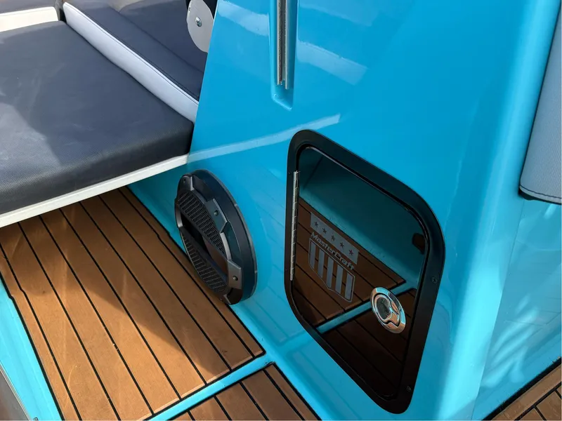 Slide: The Image of 2019 MasterCraft X24 boat interior with blue accents and teak flooring. - 32