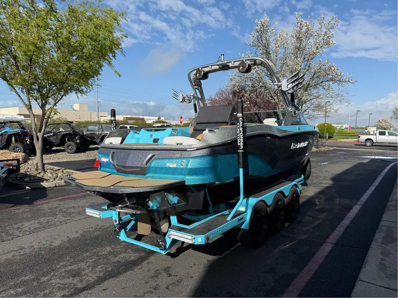 Slide: The Image of 2019 MasterCraft X24 boat on trailer, parked outdoors under a clear sky. - 4