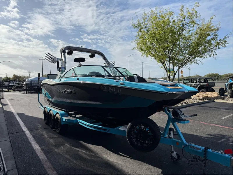 Slide: The Image of 2019 MasterCraft X24 boat on trailer in parking lot, sunny day. - 5