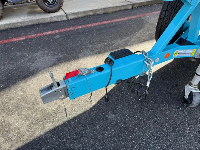 Slide: The Image of Trailer hitch of a 2019 MasterCraft X24 boat on pavement. - 7