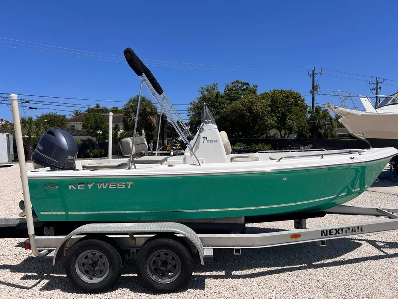 Slide: The Image of 2025 Key West 1720 Center Console boat on trailer, green hull, parked outdoors. - 1