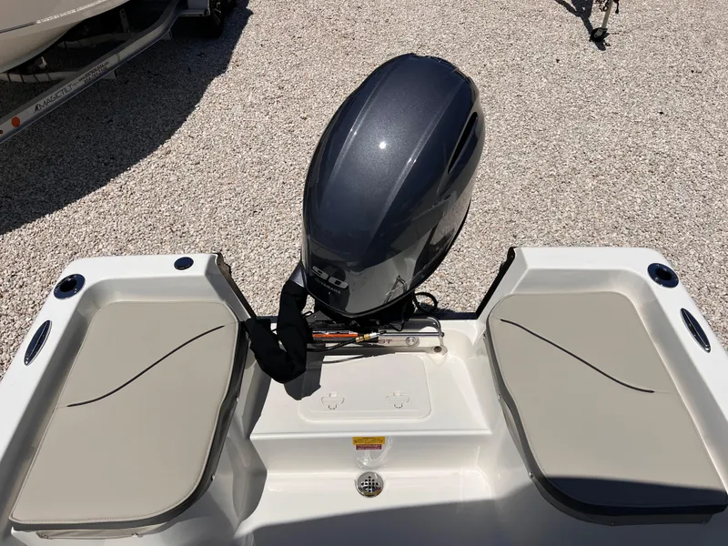 Slide: The Image of 2025 Key West 1720 Center Console boat with outboard motor, rear seating, and gravel background. - 11