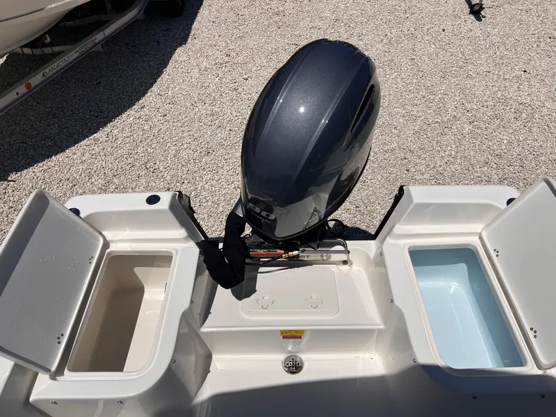 Slide: The Image of 2025 Key West 1720 Center Console boat with open storage compartments and outboard motor. - 12