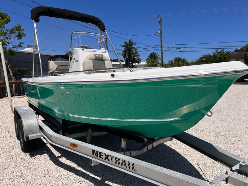 Slide: The Image of 2025 Key West 1720 Center Console boat on trailer, vibrant green hull, sunny day. - 2