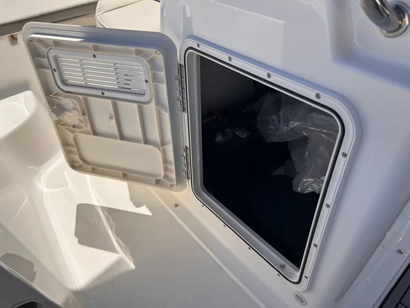 Slide: The Image of 2025 Key West 1720 Center Console boat storage compartment open, showcasing interior space. - 33