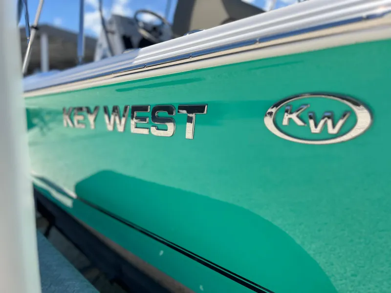 Slide: The Image of 2025 Key West 1720 Center Console boat, turquoise hull with logo, close-up view. - 35