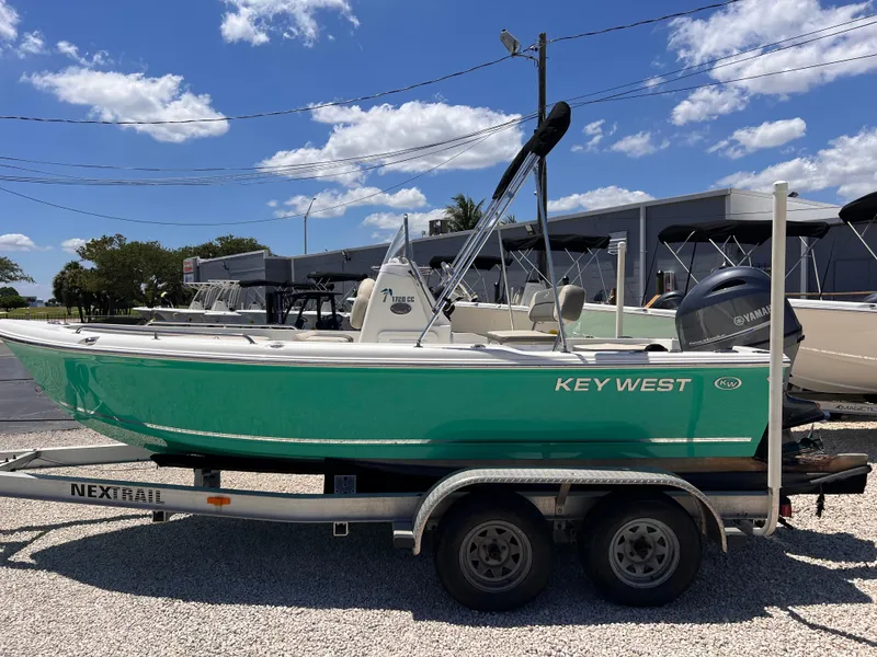 Slide: The Image of 2025 Key West 1720 Center Console boat on trailer, parked outdoors under a clear sky. - 4