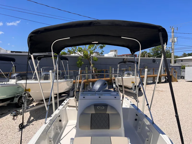 Slide: The Image of 2025 Key West 1720 Center Console boat with canopy, parked outdoors under clear blue sky. - 6