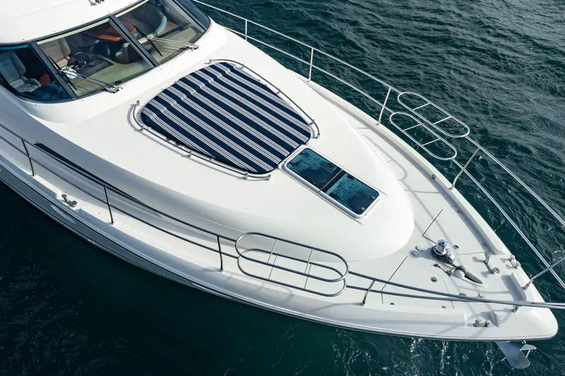 Slide: The Image of 2002 Fairline Squadron 58 yacht with striped sunpad, cruising on open water. - 14