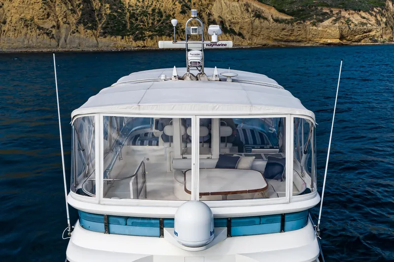 Slide: The Image of 2002 Fairline Squadron 58 yacht on water, featuring spacious deck and clear enclosure. - 16